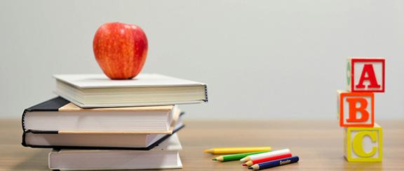 Classroom desk with apple and books