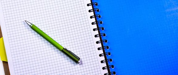 grid paper notebook with a pencil